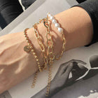 Gold-tone pearl and chain bracelet set on wrist with clasp and coin charm