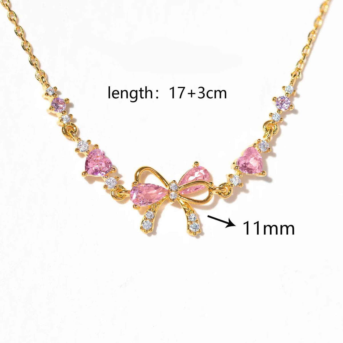 Gold-tone rhinestone bow bracelet with pink heart stones and dangling bow charm