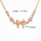 Gold-tone rhinestone bow bracelet with pink heart stones and dangling bow charm