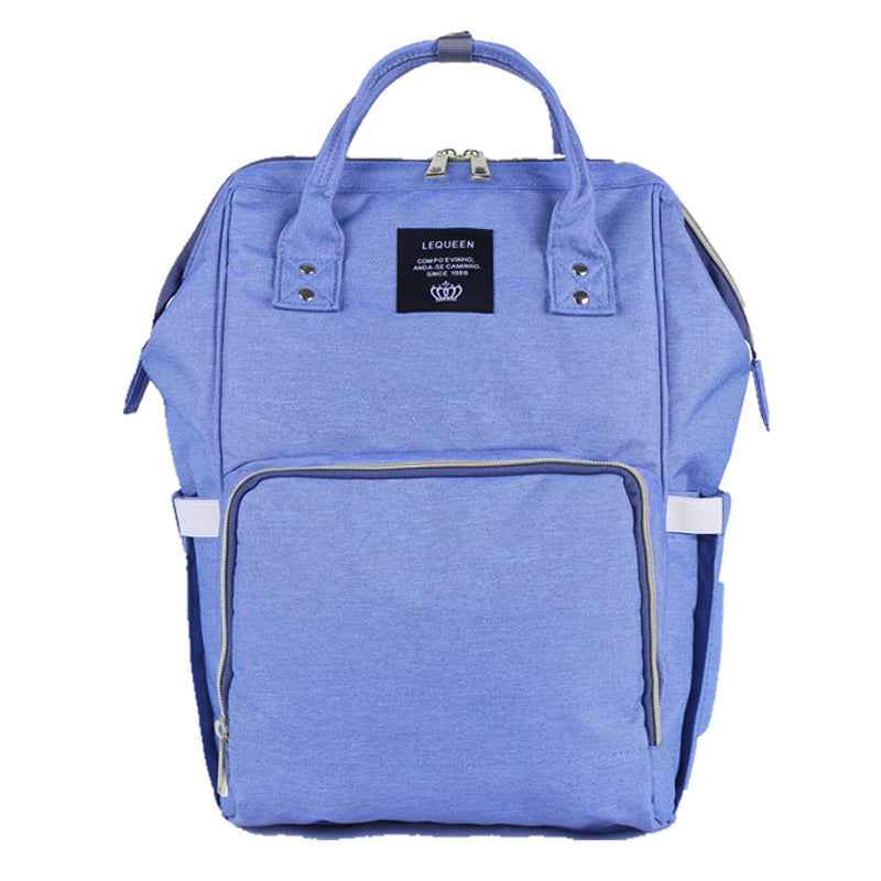 Blue maternity diaper bag with front zip pocket and two side handles, fabric exterior