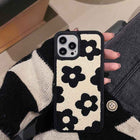 Plush floral iPhone case, cream with black flowers; visible camera cutout and raised bezel