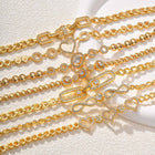 Gold-tone crystal link bracelet with heart and flower charms, close-up