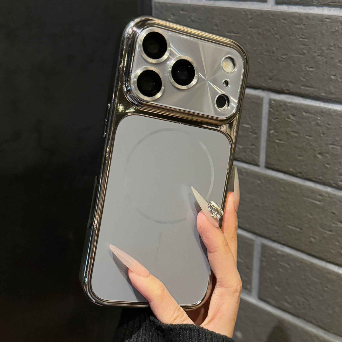 Light gray phone case with silver-toned border and raised camera lens guard