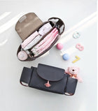 Dark stroller nappy organizer with beige insert and multiple zip pouches
