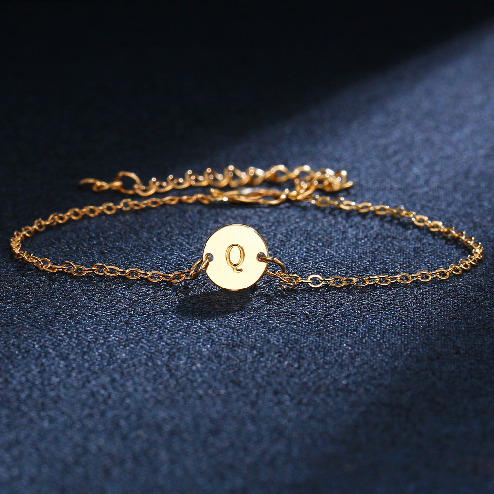 Gold-tone initial bracelet with round charm letter Q