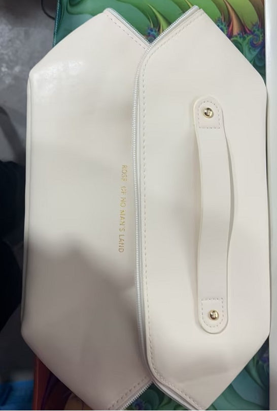 White travel cosmetic bag with side zipper pocket and gold hardware accents