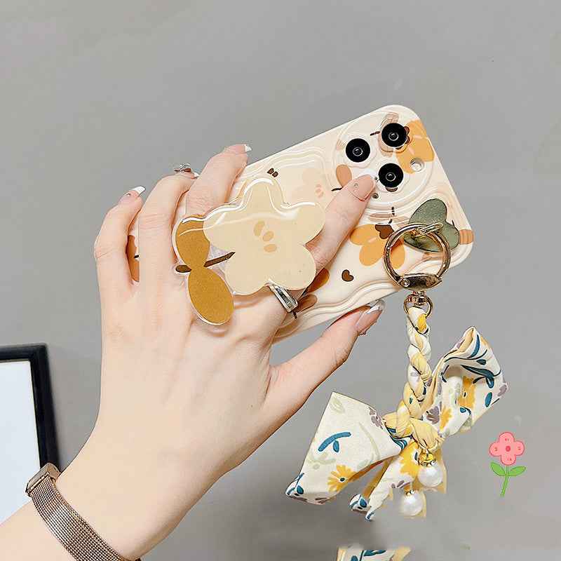 Floral bow phone case with bear-and-flower print, ring holder, and charm tassel