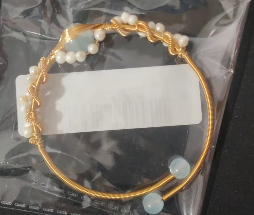 Gold cuff bracelet with clustered white pearls and pale blue disc accents
