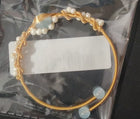 Gold cuff bracelet with clustered white pearls and pale blue disc accents