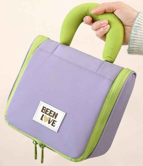 Lavender hanging makeup bag with lime handle, front logo patch, zip edge