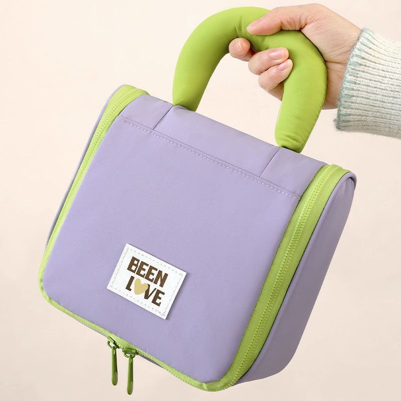 Lavender hanging makeup bag with lime handle, front logo patch, zip edge