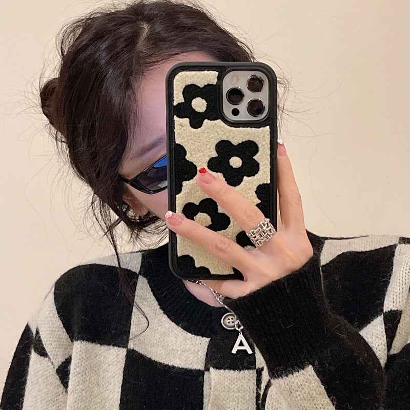 Plush floral iPhone case, cream with black flowers; phone camera cutout with textured edges