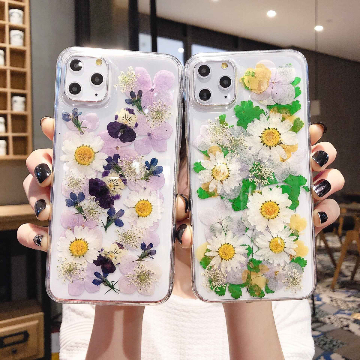 Clear iPhone case set with preserved purple flowers and yellow daisies on one, green daisies on the other
