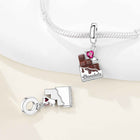 Chocolate-themed charm pendant with a pink heart gemstone on a silver bracelet