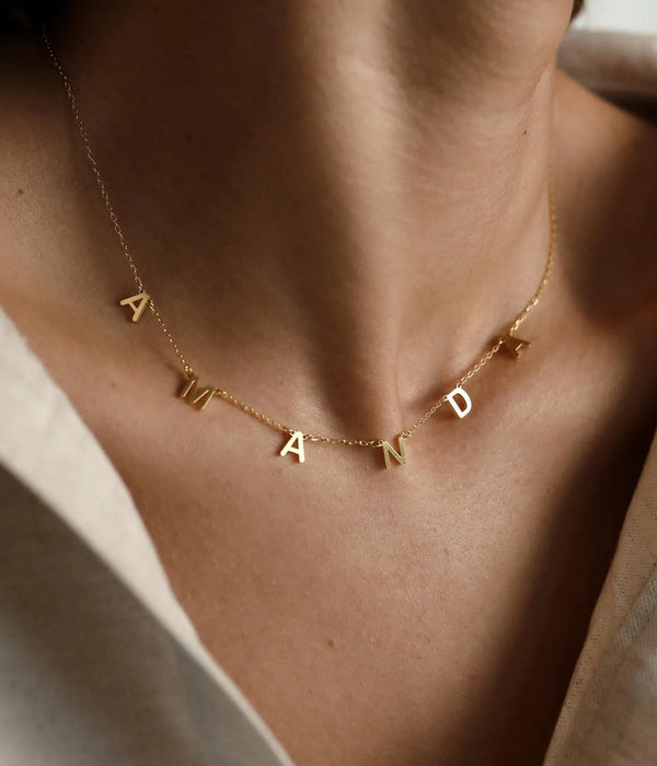 Gold initial necklace with letter charms A N D on a thin chain