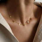 Gold initial necklace with letter charms A N D on a thin chain