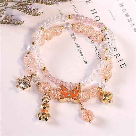 Peach and pink crystal bracelet with gold-tone charms and dangling beads