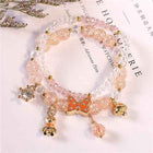 Peach and pink crystal bracelet with gold-tone charms and dangling beads