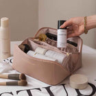 Tan cosmetic bag with zip closure, open top showing inner pockets and dividers