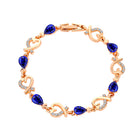 Rhinestone heart charm bracelet with royal blue stones, heart links, and crystal accents
