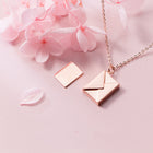 Rose gold envelope pendant necklace with small open-letter motif
