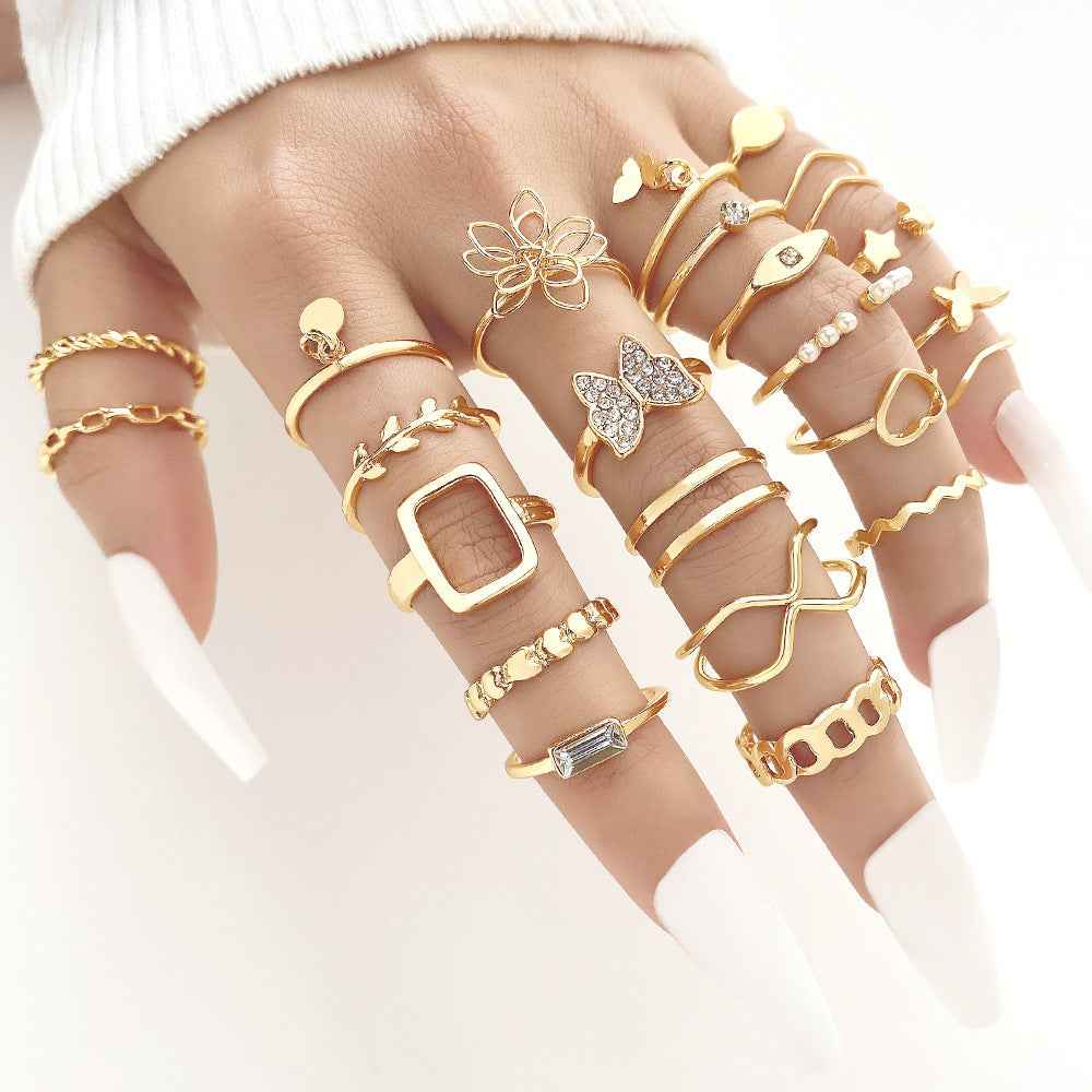 Gold ring set with hearts, butterflies, and gemstone charms; adjustable stack bands