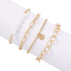 Gold-tone pearl bracelet set with oval links and bead chain charms