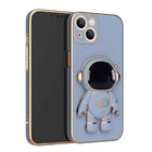 Light blue phone case with 3D astronaut charm, ring grip, and dual camera cutouts