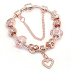 Rose gold charm bracelet with pink crystal beads and a heart charm at the end.