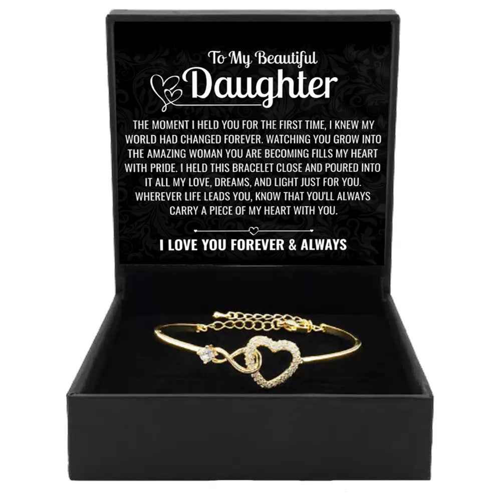 Gold open cuff bracelet with linked heart center and crystal-like stone details