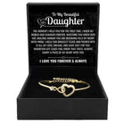 Gold open cuff bracelet with linked heart center and crystal-like stone details