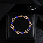 Rhinestone heart charm bracelet with deep blue stones and heart links in rose-gold tone
