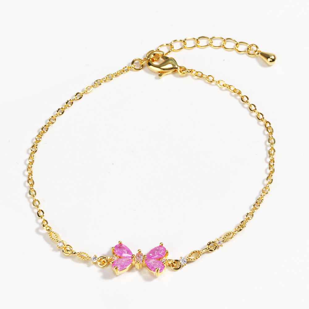 Gold chain bracelet with two pink heart-shaped rhinestone charms, lobster clasp