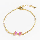 Gold chain bracelet with two pink heart-shaped rhinestone charms, lobster clasp
