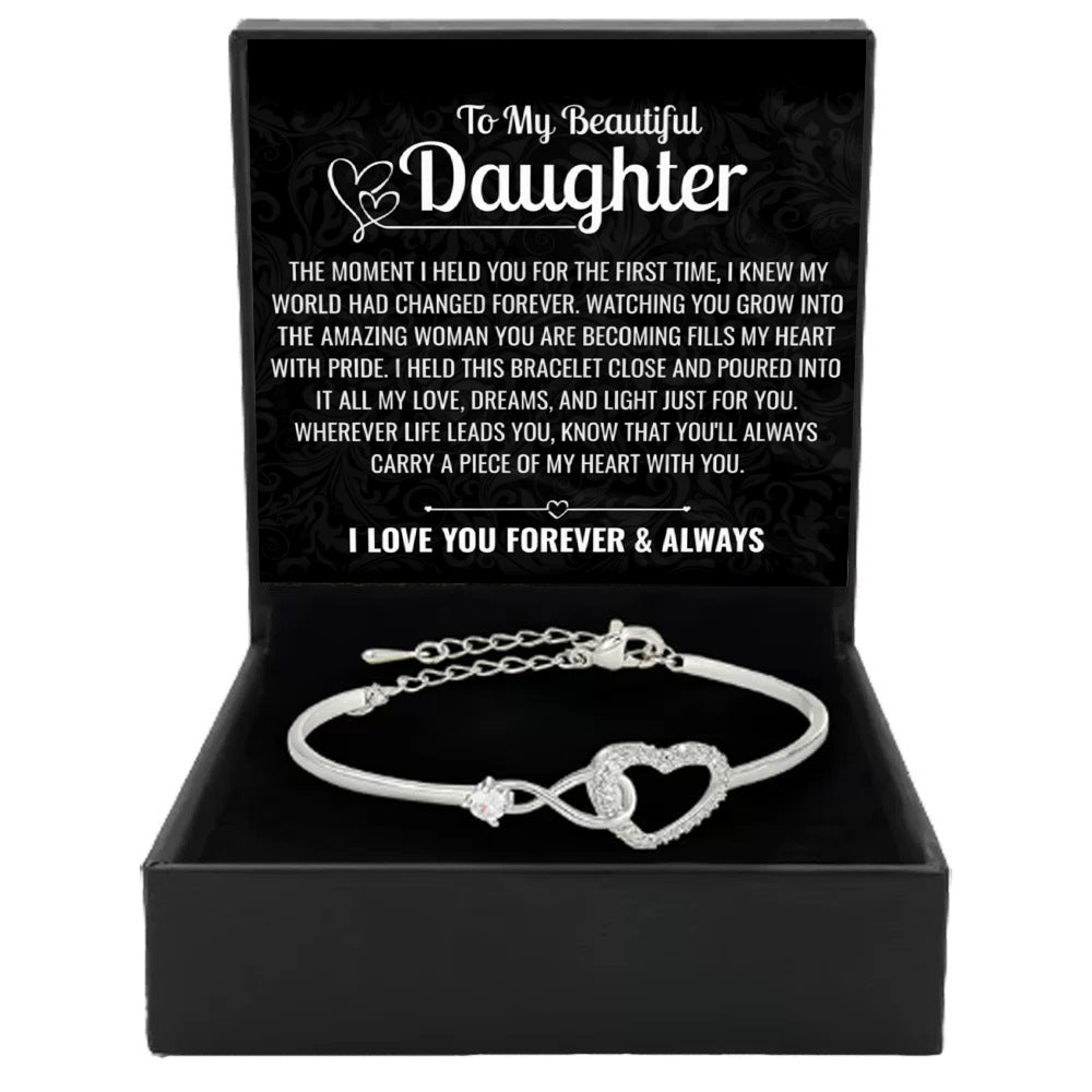 Silver open cuff bracelet with heart-shaped center and crystal-like stone details