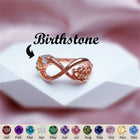 Rose-gold infinity knot ring with orange-pink gemstone cluster, twisted band