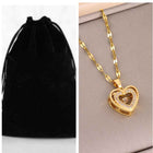 Gold heart pendant necklace with heart charm and stone details on curb-link chain
