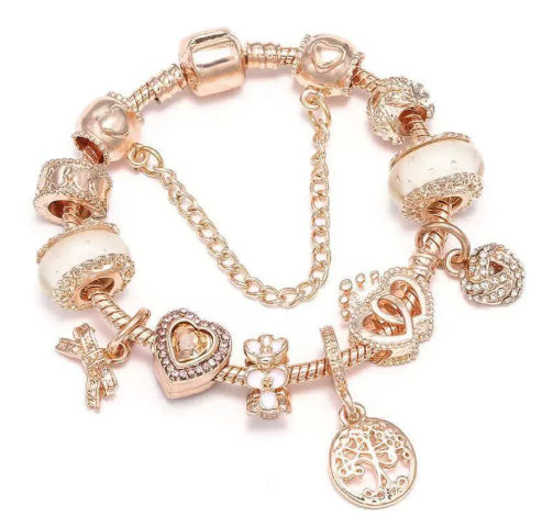 Rose gold charm bracelet with light pink beads, heart charm, and circular pendant dangle.