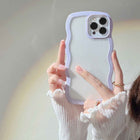 Purple silicone iPhone case with wavy candy border and raised quad-camera cutouts