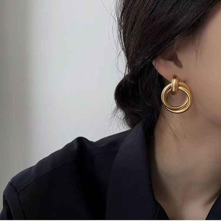 Gold circular drop earrings with layered ring ornament