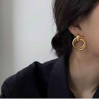 Gold circular drop earrings with layered ring ornament