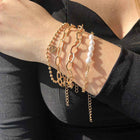Stack of gold-tone pearl chain bracelets with coin charms and long drop dangles