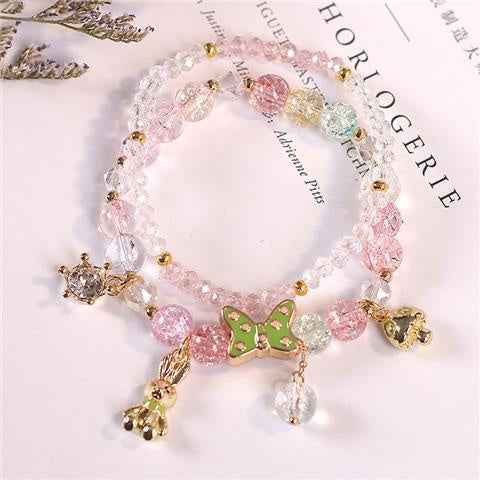 Light pink crystal bracelet with gold-tone charms and dangling beads