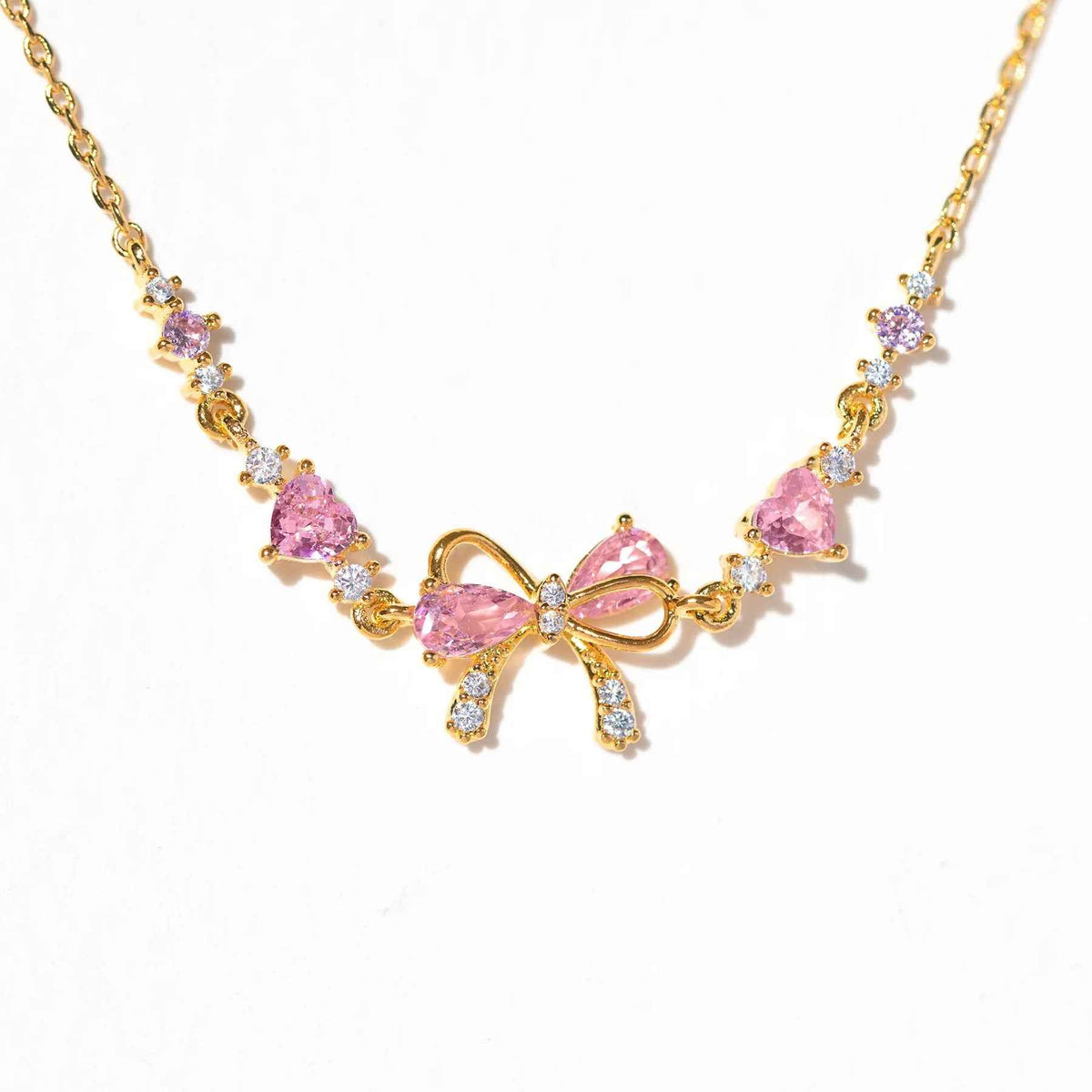 Gold-tone rhinestone necklace-style bracelet with bow and heart charms in pink