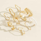 Gold-tone openwork flower rings with pearl accents, shown in flat lay