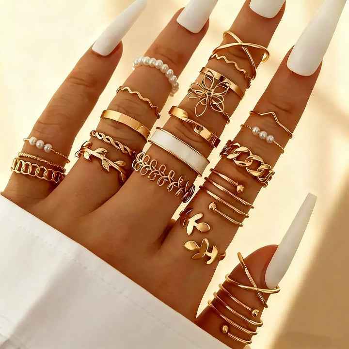 Gold adjustable heart and pearl stack rings arranged on hand