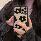 Plush floral iPhone case, cream with black flowers; raised camera cutouts and slim bumper edge