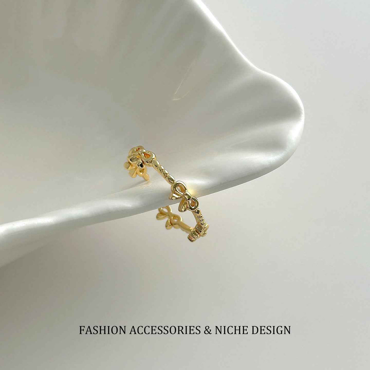 Gold-tone open bow link ring with adjustable clasp, minimalist design